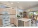 Open kitchen with white cabinets and appliances, a breakfast bar, and adjacent dining area at 16354 W Labyrinth Ln, Surprise, AZ 85374