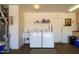 Bright laundry area with washer, dryer, utility sink, and shelving for convenient home management at 16354 W Labyrinth Ln, Surprise, AZ 85374