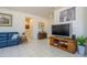 Open-concept living area with neutral tile flooring, comfortable blue seating, and a media center for entertainment at 16354 W Labyrinth Ln, Surprise, AZ 85374