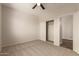 Spacious bedroom with neutral carpeting, ceiling fan, closet, and convenient hall access at 17493 N Costa Brava Ave, Maricopa, AZ 85139