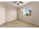 Comfortable bedroom featuring neutral carpeting, a ceiling fan, and window with lush exterior view at 17493 N Costa Brava Ave, Maricopa, AZ 85139