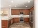 Well-equipped kitchen showcasing stainless steel appliances, granite countertops, and dark wood cabinets at 17493 N Costa Brava Ave, Maricopa, AZ 85139
