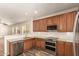 Well-equipped kitchen showcasing stainless steel appliances, granite countertops, and dark wood cabinets at 17493 N Costa Brava Ave, Maricopa, AZ 85139