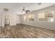 Bright living room with wood-look floors, multiple windows, and neutral paint at 17493 N Costa Brava Ave, Maricopa, AZ 85139