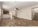 Open-concept living area with wood-look floors, a ceiling fan, and natural light at 17493 N Costa Brava Ave, Maricopa, AZ 85139