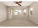Spacious carpeted bedroom offering many bright windows and natural light at 17493 N Costa Brava Ave, Maricopa, AZ 85139