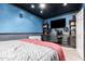 This bedroom features a ceiling fan, a desk with a gaming PC, and blue textured walls at 1751 W Mulberry Dr, Chandler, AZ 85286