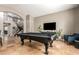 Entertaining game room with a pool table, travertine floors, bar stools, and a television at 1751 W Mulberry Dr, Chandler, AZ 85286