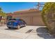 View of the three-car garage and driveway with a dark blue car parked in front of the property at 1751 W Mulberry Dr, Chandler, AZ 85286