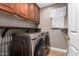 Modern laundry room with full-sized washer and dryer and shelf above at 1751 W Mulberry Dr, Chandler, AZ 85286