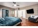 The main bedroom features a large TV, a comfortable chair, and hardwood floors at 1751 W Mulberry Dr, Chandler, AZ 85286