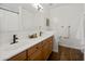 Bathroom featuring double sinks, wood cabinets, and a large mirror for a functional space at 1812 E Parkside E Ln, Phoenix, AZ 85024
