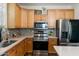 Bright kitchen featuring stainless steel appliances, mosaic backsplash, and warm wood cabinetry at 1812 E Parkside E Ln, Phoenix, AZ 85024