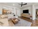 Spacious living room featuring a neutral sofa, wood floors, and large television for entertainment at 1812 E Parkside E Ln, Phoenix, AZ 85024