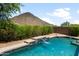 Sparkling pool featuring a cascading waterfall with beautiful landscaping and a mountain backdrop at 1812 E Parkside E Ln, Phoenix, AZ 85024
