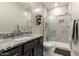 Bathroom with granite counters, shaker cabinets and a walk-in shower with a glass enclosure at 18368 W Long Lake Rd, Goodyear, AZ 85338