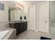 Bathroom showcasing a soaking tub, granite counters, shaker cabinets and a walk-in shower at 18368 W Long Lake Rd, Goodyear, AZ 85338