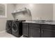 Functional laundry room equipped with modern washer and dryer, ample counter space, and storage cabinets at 18368 W Long Lake Rd, Goodyear, AZ 85338