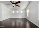 Bright bedroom featuring hardwood floors, a ceiling fan, and three large windows at 1918 E Megan St, Gilbert, AZ 85295