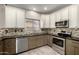 Modern kitchen featuring stainless steel appliances, granite countertops, tile backsplash, and neutral colored cabinetry at 1918 E Megan St, Gilbert, AZ 85295
