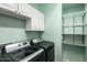 Functional laundry room with modern appliances, cabinetry, and shelving at 1918 E Megan St, Gilbert, AZ 85295
