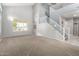 Bright living room with vaulted ceilings, neutral carpet, large windows, and a staircase at 1918 E Megan St, Gilbert, AZ 85295