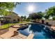 Stunning pool with a diving board, rock features, and lush landscaping in a well-maintained backyard at 1918 E Megan St, Gilbert, AZ 85295