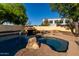 Beautiful pool with rock features and mature trees, offering a serene and private outdoor space at 1918 E Megan St, Gilbert, AZ 85295