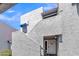 View of the building's facade featuring a stucco exterior, stairs, and a gated entrance at 220 N 22Nd Pl # 2036, Mesa, AZ 85213