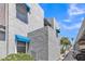 Property exterior view with stucco walls, blue awnings, mature trees, and covered parking at 220 N 22Nd Pl # 2036, Mesa, AZ 85213
