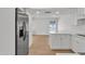 Bright kitchen with stainless steel refrigerator, white cabinets, and hardwood flooring at 220 N 22Nd Pl # 2036, Mesa, AZ 85213