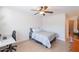 Bedroom with queen bed, ceiling fan, and desk area with natural light at 3404 E Lavey Ln, Phoenix, AZ 85032