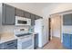 Kitchen features a white refrigerator and stove, as well as painted cabinets at 3404 E Lavey Ln, Phoenix, AZ 85032