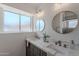 Modern bathroom featuring dual sinks with marble countertops, round mirrors, and stylish fixtures at 3608 W Fairview Ln, Chandler, AZ 85226