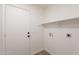 Bright laundry room featuring tile floors, overhead shelf, and door to outside at 3608 W Fairview Ln, Chandler, AZ 85226