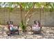 Inviting backyard seating area with decorative pillows, gravel landscape, and shade from a beautiful tree at 3839 E Friess Dr, Phoenix, AZ 85032