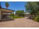 Expansive backyard with artificial turf, shaded patio, gravel landscaping, and comfortable seating at 3839 E Friess Dr, Phoenix, AZ 85032