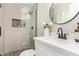 Updated bathroom featuring a glass shower, stylish tile, and round mirror above a modern vanity at 3839 E Friess Dr, Phoenix, AZ 85032