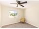 Bright bedroom features neutral walls, ceiling fan, and a comfortable chair by the window at 3839 E Friess Dr, Phoenix, AZ 85032