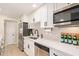Modern kitchen offers stainless steel appliances, herringbone backsplash, and white cabinets with black hardware at 3839 E Friess Dr, Phoenix, AZ 85032