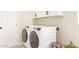Laundry room with modern washer and dryer and wall-mounted cabinets for ample storage space at 3839 E Friess Dr, Phoenix, AZ 85032