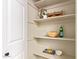 Walk-in pantry features ample shelving for storage, decorated with wooden bowls and pitchers with flower arrangements at 3839 E Friess Dr, Phoenix, AZ 85032