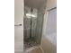 Bathroom with modern glass shower featuring white and patterned tile at 3844 N 88Th Ln, Phoenix, AZ 85037