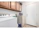 Bright laundry room with washer, dryer, and upper cabinets for ample storage and tiled flooring at 403 N Monte Vista St, Chandler, AZ 85225