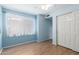 Bedroom with hardwood floors, a window with white sheer curtains, and a closet at 4135 E Altadena Ave, Phoenix, AZ 85028