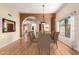 Elegant dining room with hardwood floors, arched doorways, and a stylish pendant light fixture at 4135 E Altadena Ave, Phoenix, AZ 85028