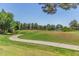 Lush green golf course with rolling hills, a pond, and walking path for recreation and leisure at 4135 E Altadena Ave, Phoenix, AZ 85028