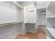 Bright walk-in closet with shelves, clothing rods, lighting, and dark countertop at 4135 E Altadena Ave, Phoenix, AZ 85028