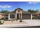 Inviting single-story home featuring a stone facade, a two-car garage, and desert landscaping for low maintenance at 42515 W Peters Dr, Maricopa, AZ 85138