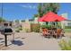 Community area with a red umbrella, seating, and a barbeque grill at 4600 N 68Th St # 351, Scottsdale, AZ 85251